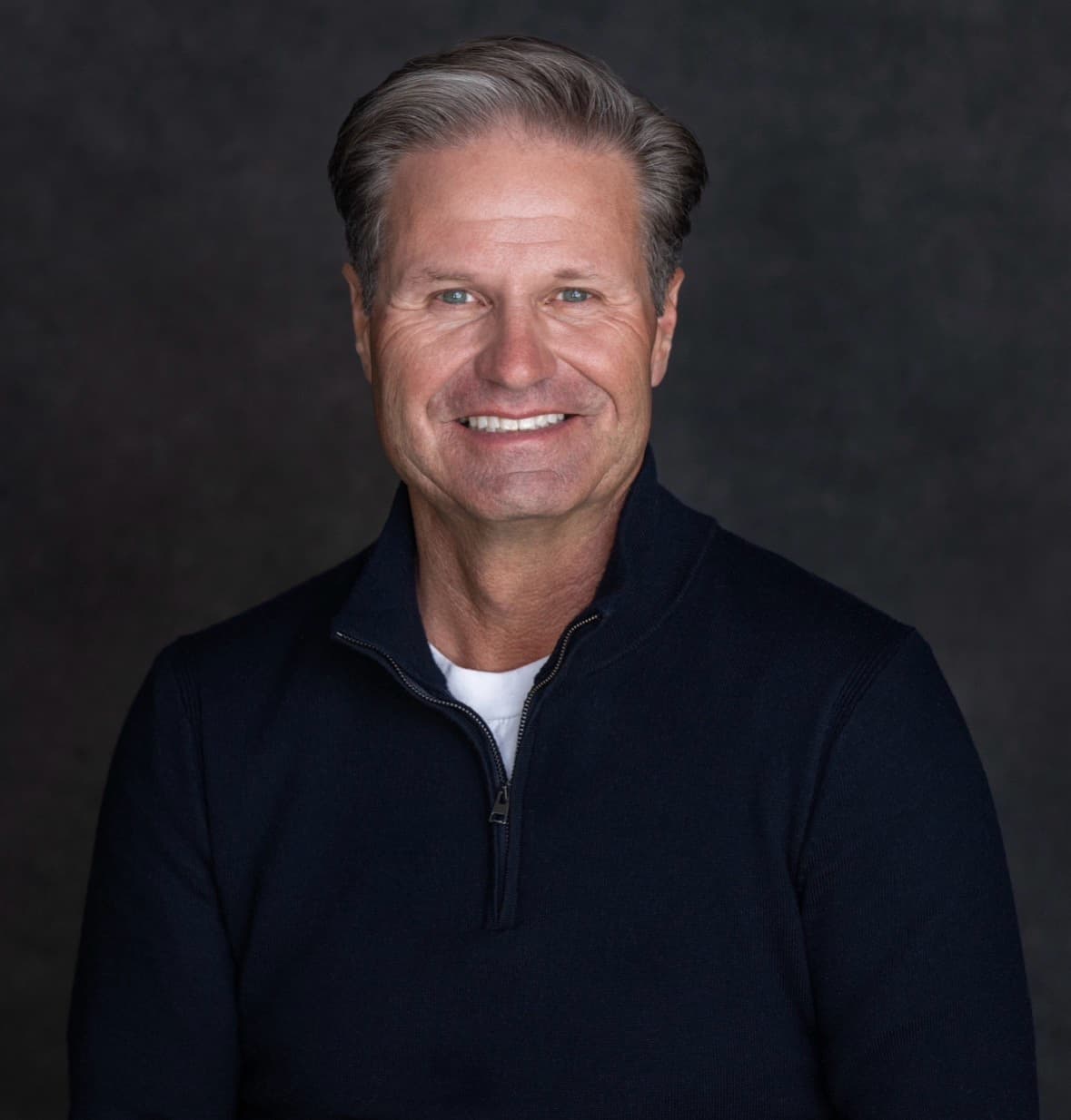 Morley Abey smiling in a navy quarter-zip sweater