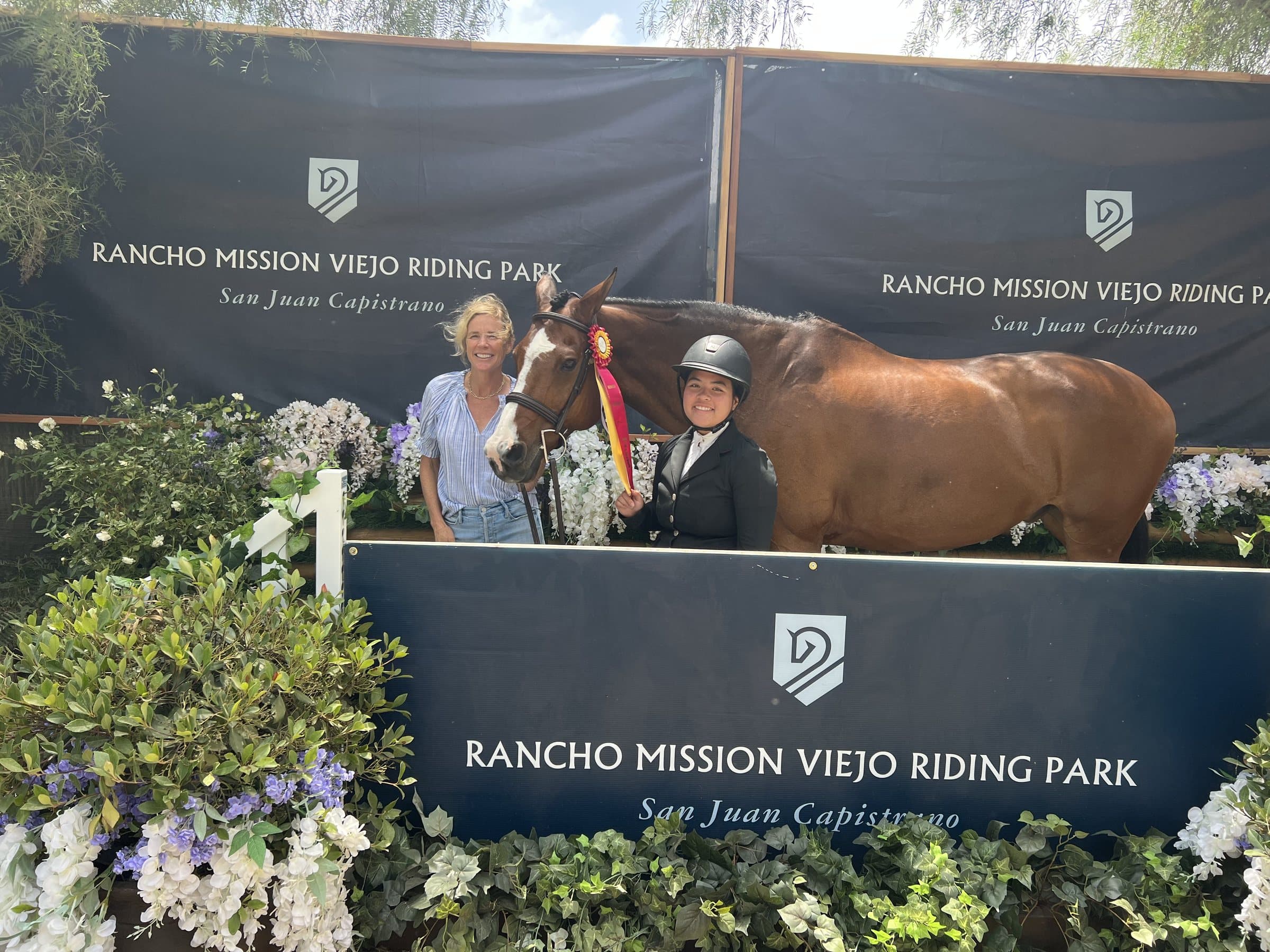 A rider, supporter and chestnut horse at a show presentation
